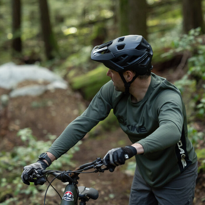 Mann mit Mountainbike und passendem Helm im Wald